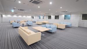 大阪市にある東横INN大阪なんばのテーブルと青い椅子が備わる待合室