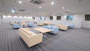 a waiting room with tables and blue chairs at Toyoko Inn Osaka Namba in Osaka