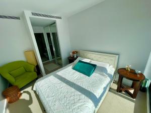 a bedroom with a bed and a green chair at Yarra Accommodation in Melbourne