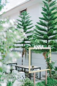 een tafel en een dennenboom voor een gebouw bij Annahouse in Chiang Rai