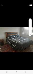 a bedroom with a bed with a black comforter at vip huertos familiares in San Pedro de la Paz