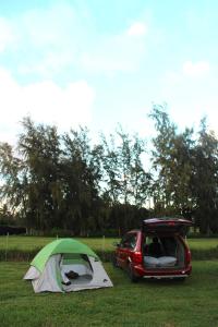 a tent and a car parked in a field at Maleka Farm Camper-Vans in Laie