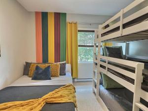 a bedroom with two bunk beds and a balcony at Plage et piscine au Mont Blanc in Saint-Faustin