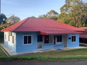 a small blue and white building with a red roof at Sarifah homestay in Melaka