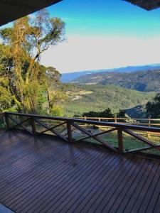 a wooden deck with a view of the mountains at Refúgio Linda Vista in Canela