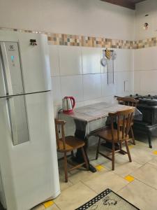 a kitchen with a table and chairs and a refrigerator at Refúgio Linda Vista in Canela