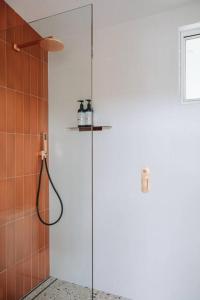 a shower with a glass door in a bathroom at Retro Retreat - by Coast Hosting in Terrigal