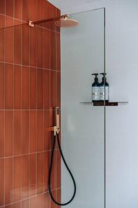 a shower with a hose in a bathroom at Retro Retreat - by Coast Hosting in Terrigal