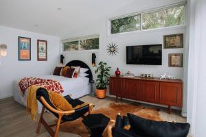 a bedroom with a bed and a tv on a wall at Retro Retreat - by Coast Hosting in Terrigal