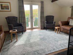 a living room with two chairs and a couch and a table at Braffin @ Fellside Farm, Pennington, Ulverston in Pennington