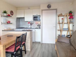 Appartement Montvalezan-La Rosière, 2 pièces, 6 personnes - FR-1-275-202 في Montvalezan: مطبخ صغير مع طاولة خشبية وقمة كونتر