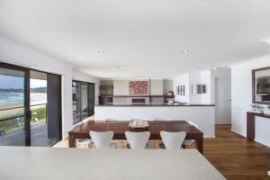an open kitchen and dining room with a table and chairs at Beach Road in Mollymook