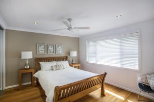 a bedroom with a large bed and a window at Beach Road in Mollymook
