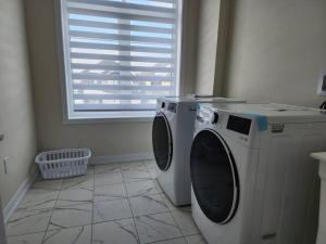 - un lave-linge et un sèche-linge dans une chambre avec fenêtre dans l'établissement Entire home near Hamilton, à Caledonia