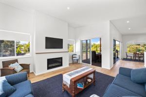 a living room with a couch and a fireplace at Bombora Pearl in Mollymook