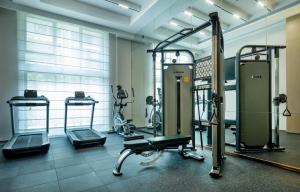 a gym with treadmills and machines in a room at Guangzhou Drimin House Hotel - Canton Fair Free Shuttle Bus in Guangzhou