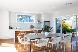 a kitchen and dining room with a black table and chairs at Coastal, Pet-Friendly Luxe in Narrawallee +12 photos