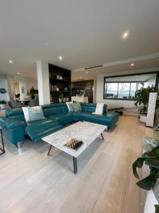 ein Wohnzimmer mit einem blauen Sofa und einem Tisch in der Unterkunft Lakeview Luxe - EV charger, Pool, Gym, Location + in Kingston 