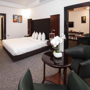 ein Hotelzimmer mit einem Bett, einem Tisch und Stühlen in der Unterkunft Torino Hotel Amman in Amman