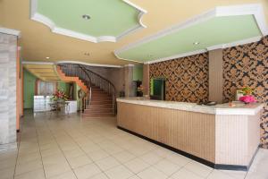 a hotel lobby with a reception counter and stairs at Reddoorz Syariah At Hotel Matahari 2 in Jambi