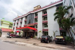 a building with cars parked in front of it at Reddoorz Syariah At Hotel Matahari 2 in Jambi
