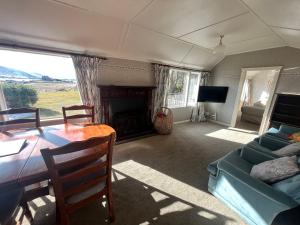 a living room with a table and a fireplace at Garden Cottage - Lake Tekapo in Lake Tekapo