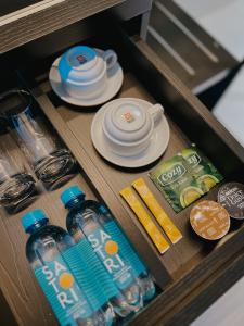 a drawer with plates and bottles of water and food at The Concept Hotel HCMC- District 1 in Ho Chi Minh City