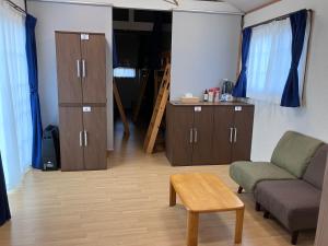 - un salon avec un canapé, une chaise et une table dans l'établissement Kakunodate Guest House Choux, à Senboku