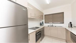 a white kitchen with a refrigerator and a sink at Tenerife unit 2 in Forster