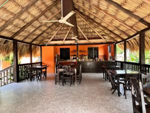 a dining area with tables and chairs and a kitchen at Bacalar Sunshine in Bacalar