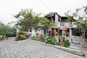 a house with a garden in front of it at RedDoorz Syariah At Wisma Djokorio Poncokusumo in Gubukklakah