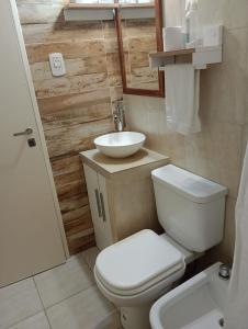 a bathroom with a white toilet and a sink at Atenea in Chivilcoy