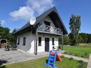 a small white house with a disk on the roof at Bright and friendly furnished holiday home in Kopalino in Kopalino