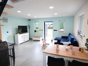 a living room with blue walls and a blue couch at Bright and friendly furnished holiday home in Kopalino in Kopalino