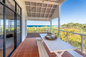 a porch with a picnic table and the ocean at Sea Spell I Private Properties in Dunsborough
