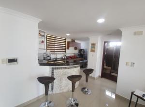 a kitchen with stools in the middle of a room at Ubicacion y comodidad en una Suit in Manta