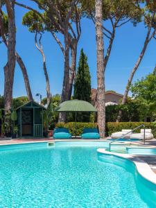 a swimming pool with chairs and trees at La Serena Hotel FDM in Forte dei Marmi