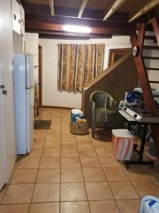 a kitchen with a tile floor and a refrigerator at Anchor Aweigh Chalet 86 in Hibberdene