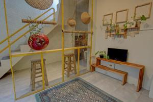a living room with a tv and some stools at OYO 92825 Kamar Lombok in Kuripan