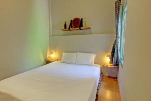 ein Schlafzimmer mit einem weißen Bett in einem Zimmer in der Unterkunft OYO 92825 Kamar Lombok in Kuripan
