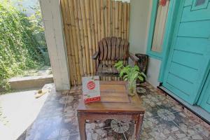 una sedia seduta su un tavolo di fronte a una porta di OYO 92825 Kamar Lombok a Kuripan