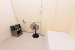um pequeno quarto com uma ventoinha e uma televisão em SPOT ON 92843 Paris Syariah em Nagoya