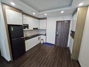 a kitchen with white cabinets and a black refrigerator at Ấm cúng, hiện đại, tiện nghi! in Hai Phong
