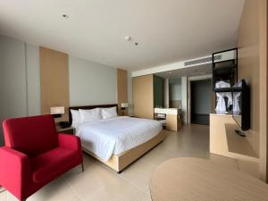 a bedroom with a bed and a red chair at The Cam Ranh Resort all Luxury Service in Miếu Ông +38 photos