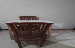 a wooden table and two chairs in a room at OYO Life 92842 Homestay Balearjosari in Blimbing