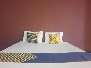 a bed with blue and yellow pillows on it at OYO Life 92842 Homestay Balearjosari in Blimbing +21 photos
