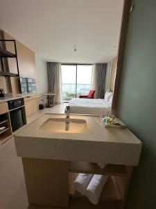a bathroom with a sink and a bed in a room at The Arena Cam Ranh Resort all Luxury Service in Miếu Ông