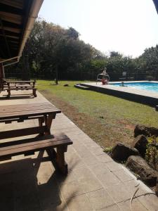 a couple of benches sitting next to a swimming pool at Anchor Aweigh Chalet 86 in Hibberdene
