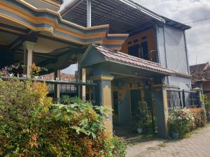 a house with a porch and a balcony at SPOT ON 92857 Kos Haji Jakfar Syariah in Banyuwangi