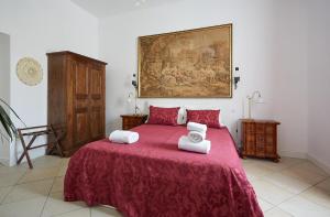 Un dormitorio con una cama roja con toallas. en LE CAMERE di VITTORIA en Bracciano